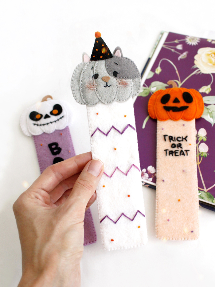 Close-up of felt Halloween bookmarks with pumpkin and cat faces
